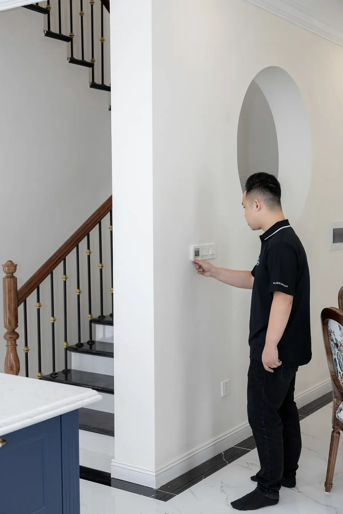 Technicien réglant un thermostat à domicile